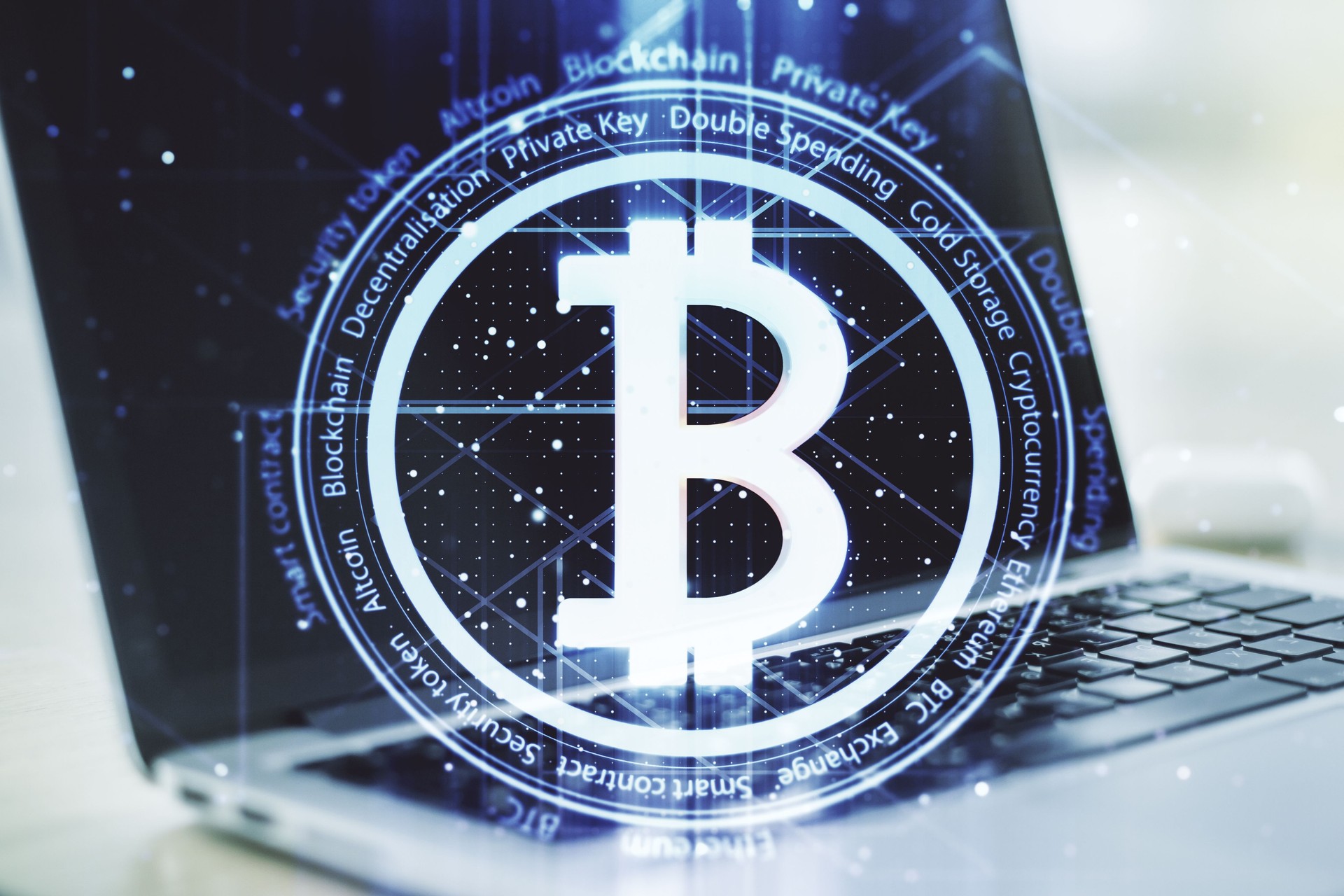 Double exposure of creative Bitcoin symbol with modern laptop on background. Cryptocurrency concept